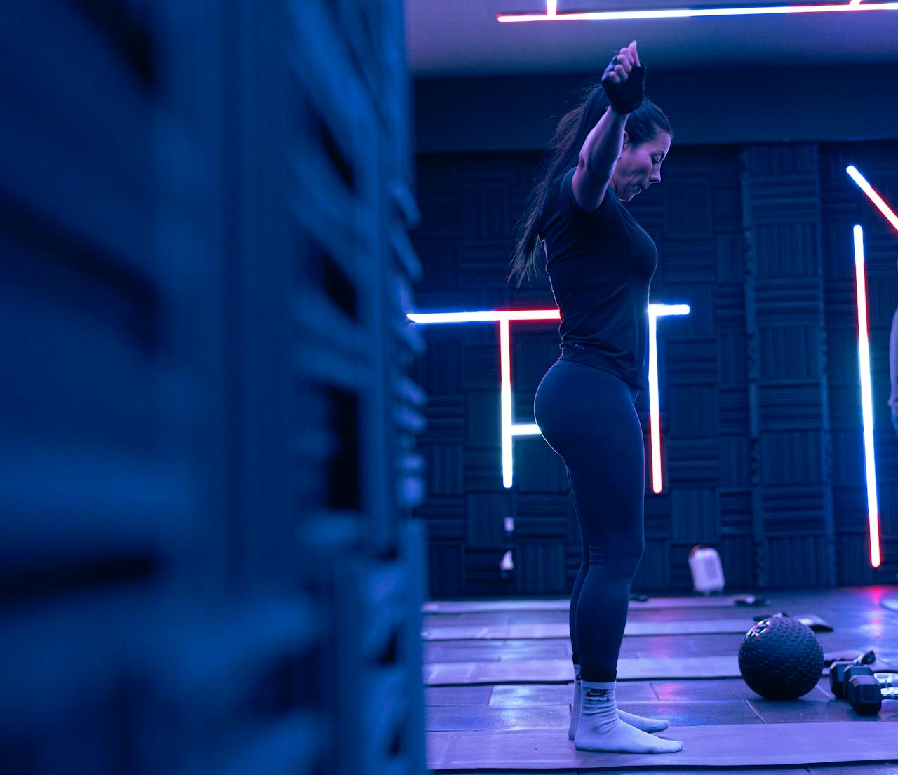 about-01 Fitness enthusiast exercising in a stylish neon-lit studio, embodying strength and focus.